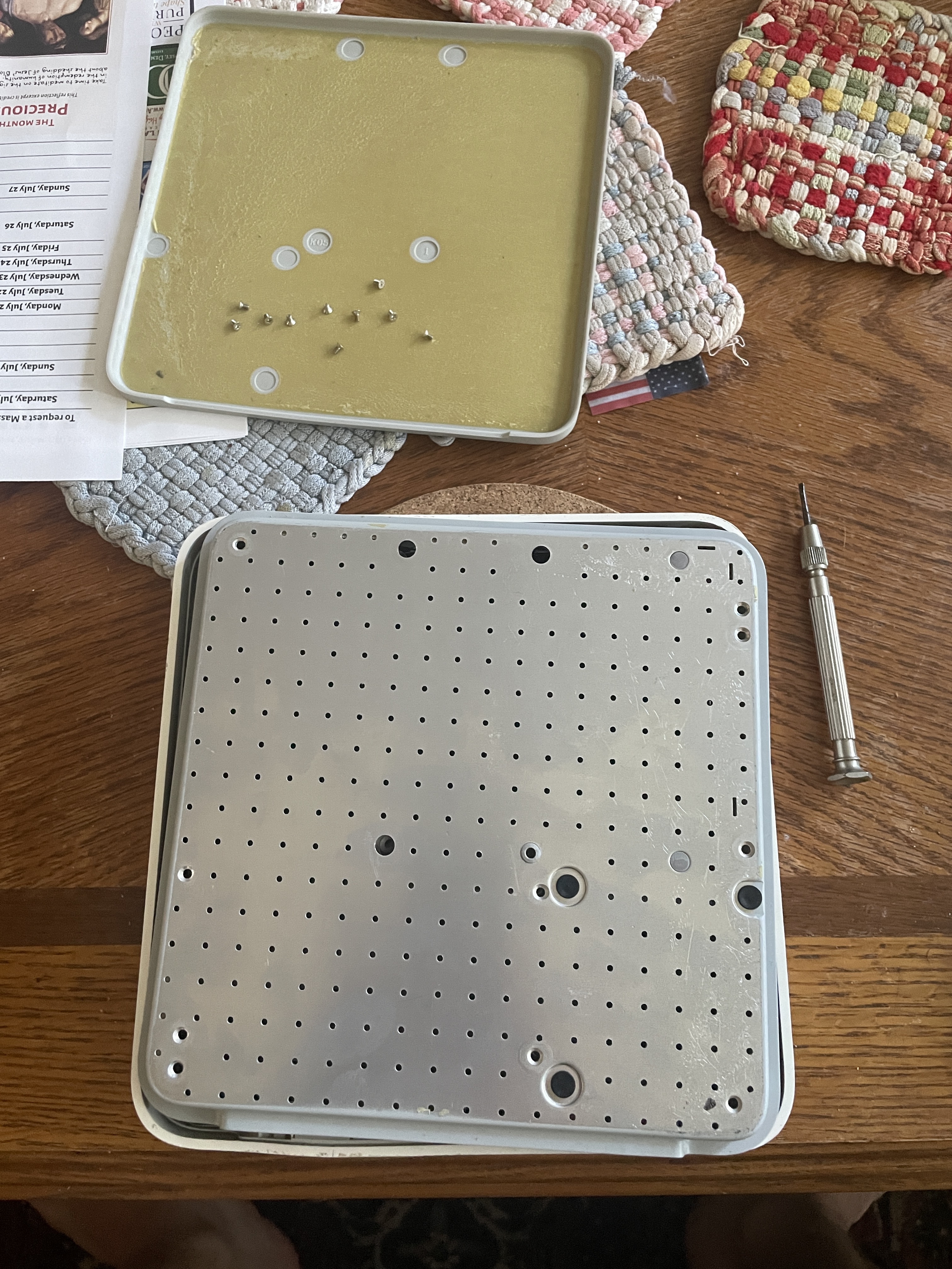 The bottom cover has had all the screws removed and is laying on a coffee table